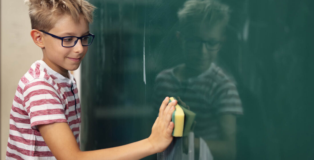 Little boy cleaning the chalkboard before the lesson Shot with Nikon D850