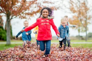 Childern runing in fall leaves-494157652